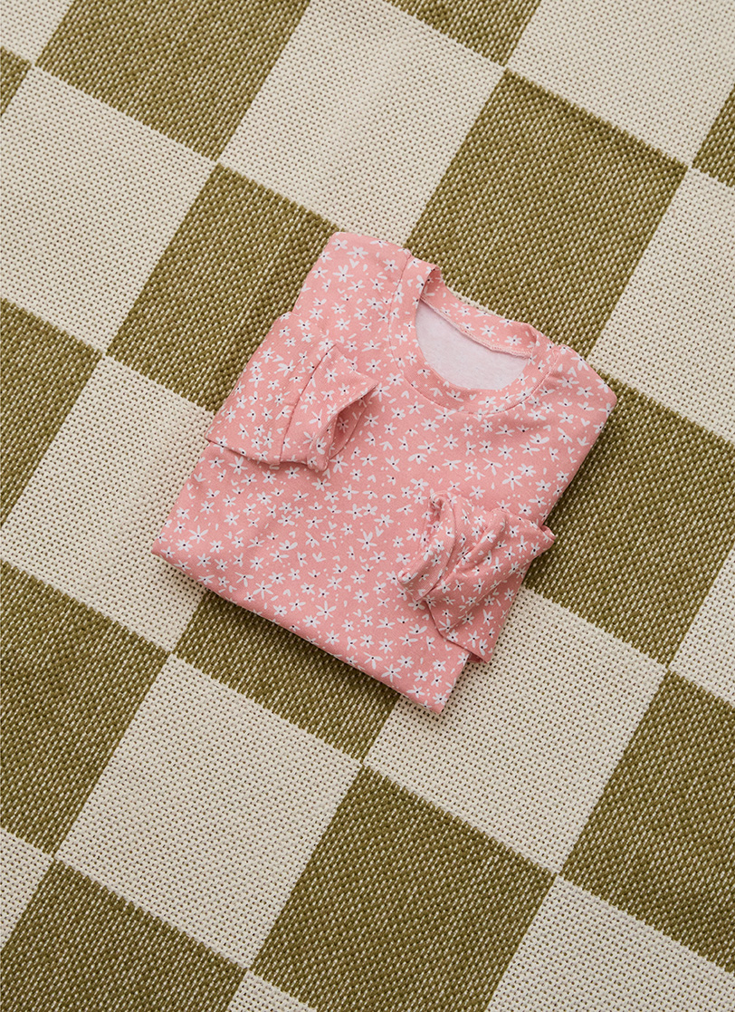 Roze pidžama za djevojčice stoji složena na podu