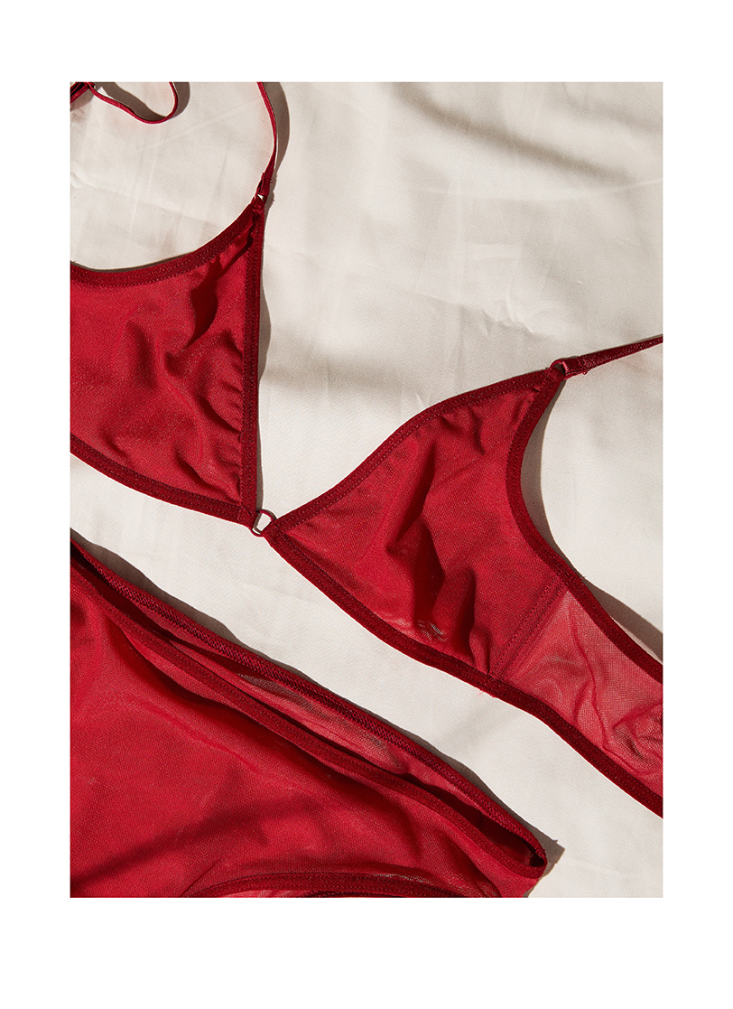 Ženski crveni ves stoji na beloj posteljini