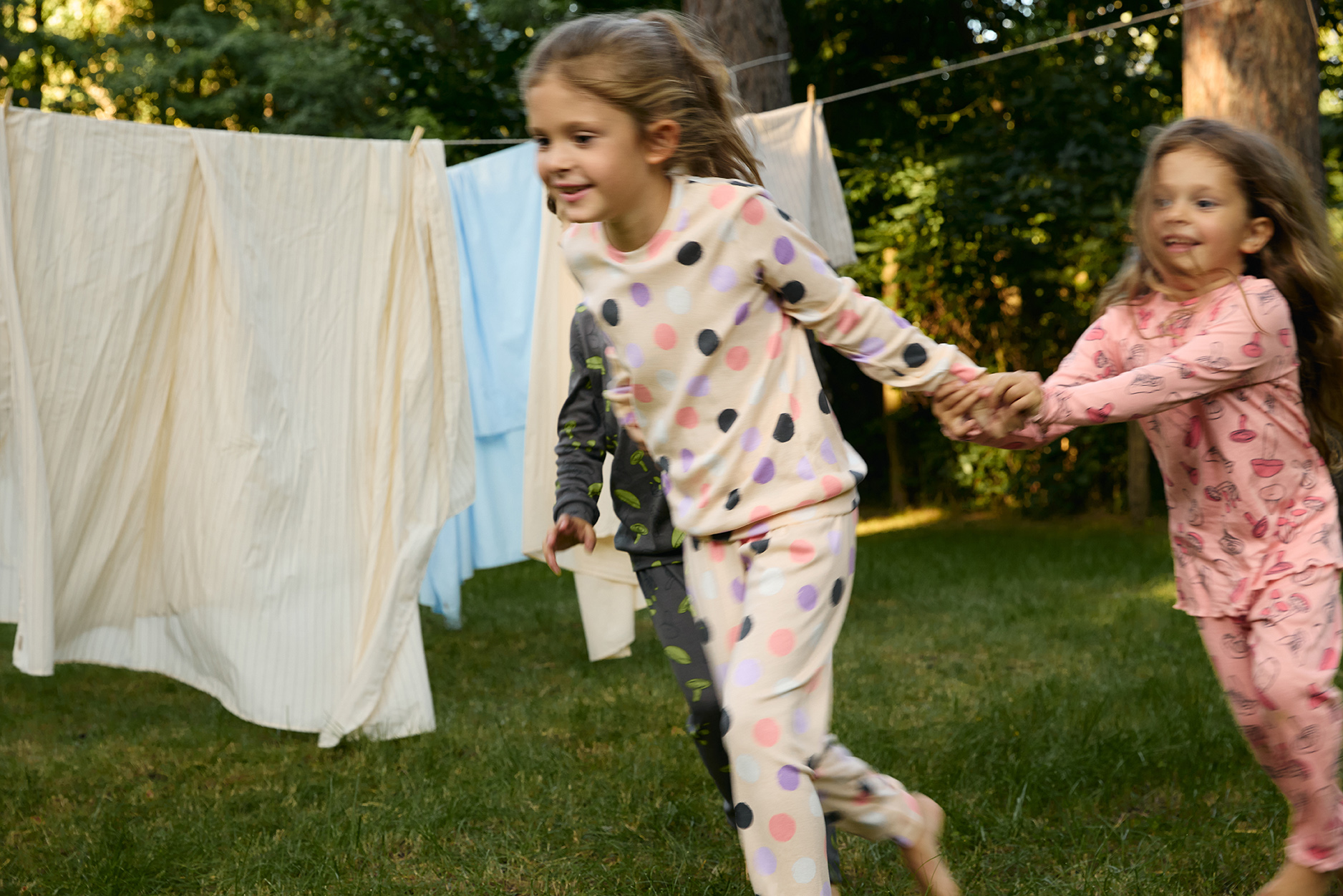 Dve djevojčice u roze pidžamama trče napolju 