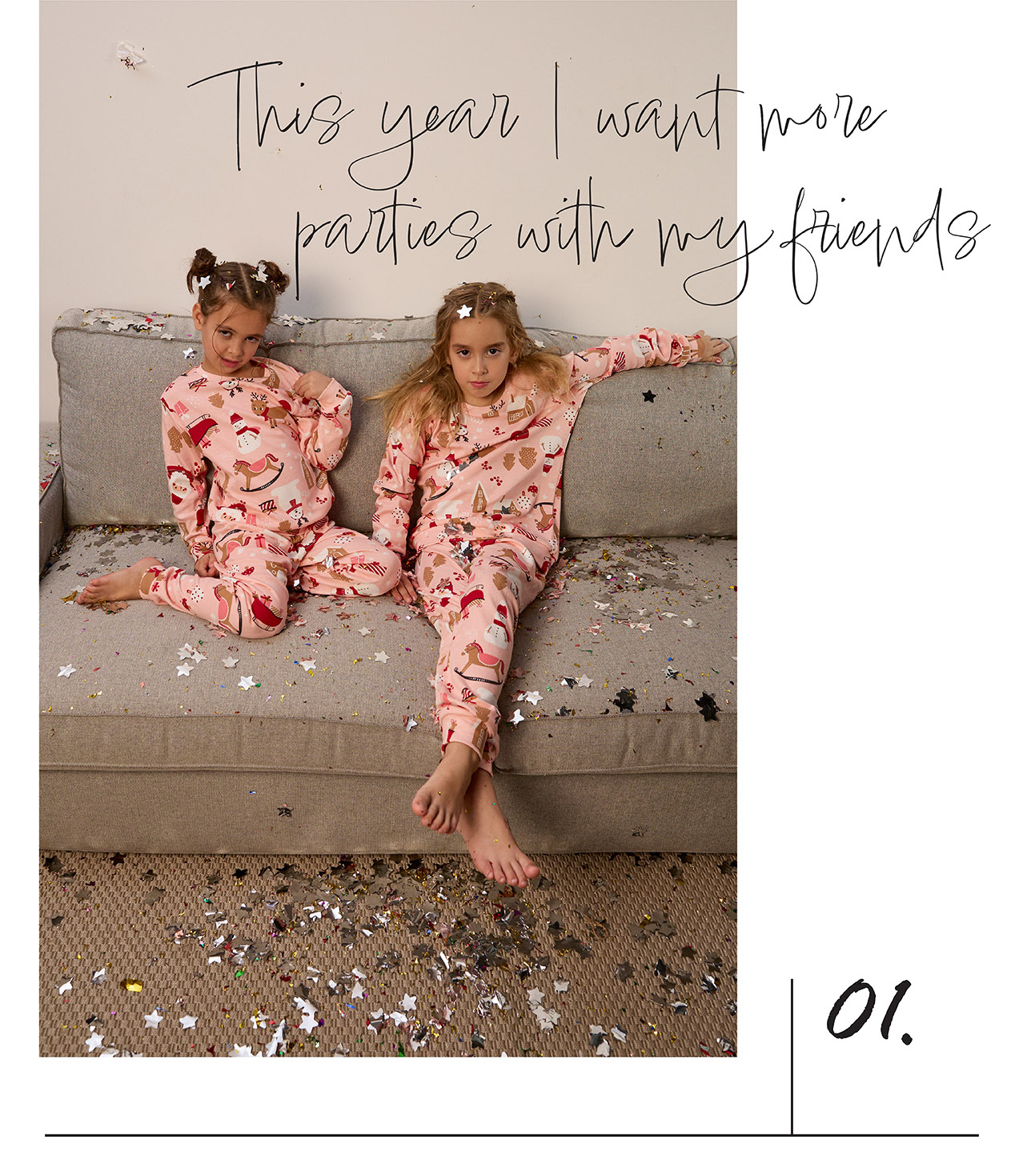 Dve djevojčice sede na krevetu u roze pidžamama sa novogodičnjim motivima